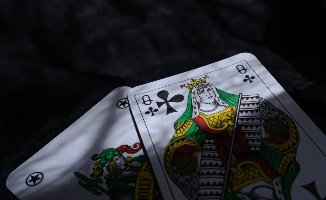 A close-up of two playing cards under dramatic lighting, emphasizing chance and mystery.