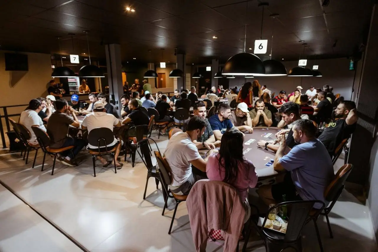 Intense poker game in a lively casino with multiple players. Experience the thrill and strategy of poker.