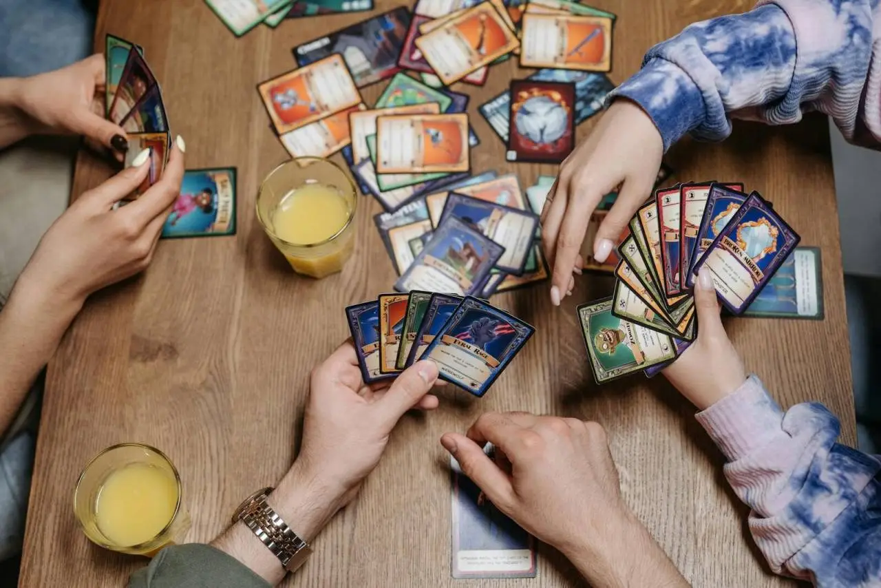Close-up of friends playing a card game at a table, fostering socialization and togetherness.