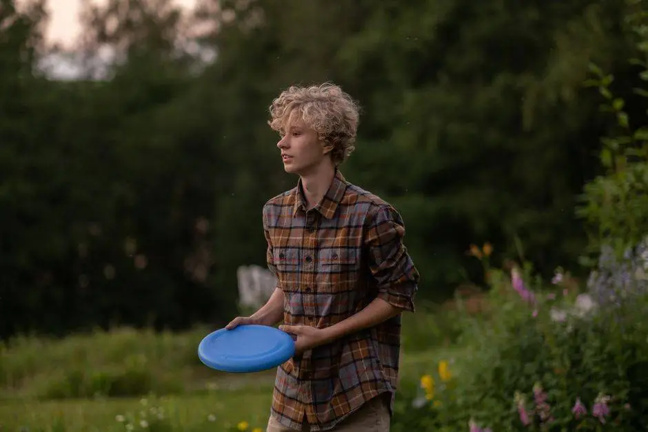 Teenage boy enjoying a game of frisbee in the countryside during a summer day.