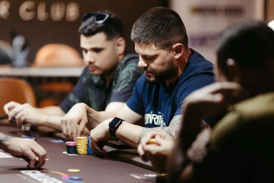 Players focused on a poker game at a casino table, showcasing intense strategies and concentration.