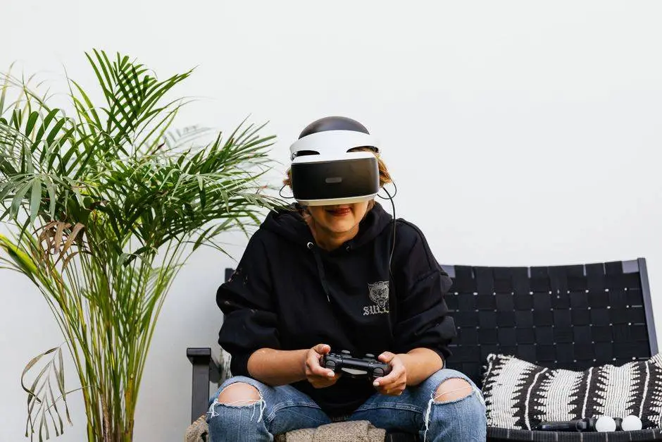 A woman wearing a VR headset and holding a gaming controller while relaxing outdoors.