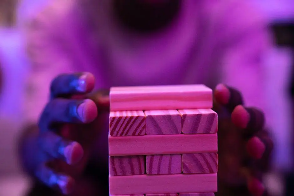 A vibrant close-up capture of hands stacking wooden blocks in a game setting under neon lighting.